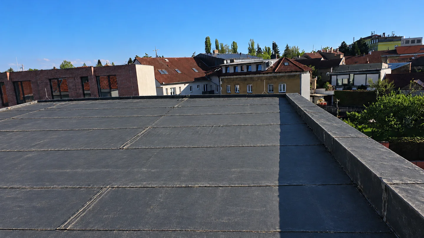 Původní asfaltový povrch střechy: AI rekonstrukce podle fotografie před renovací, sjednocená do pohledu po dokončení.
